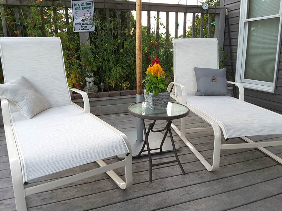 Photo of white chaise lounges on a deck