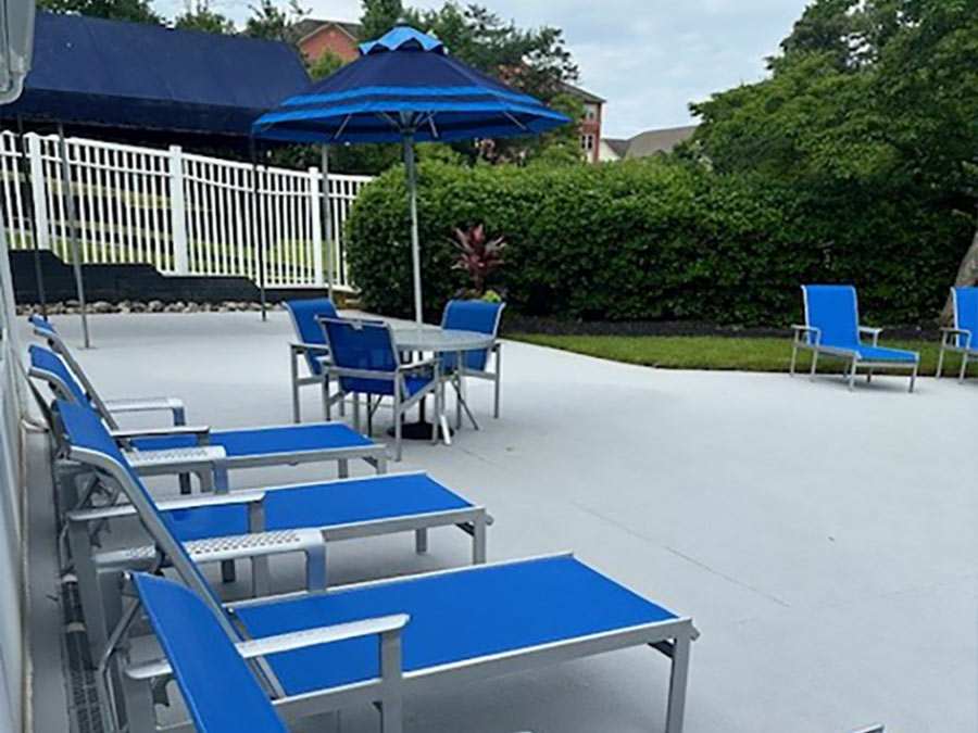 Photo of patio chairs and chaise lounges on a cement patio